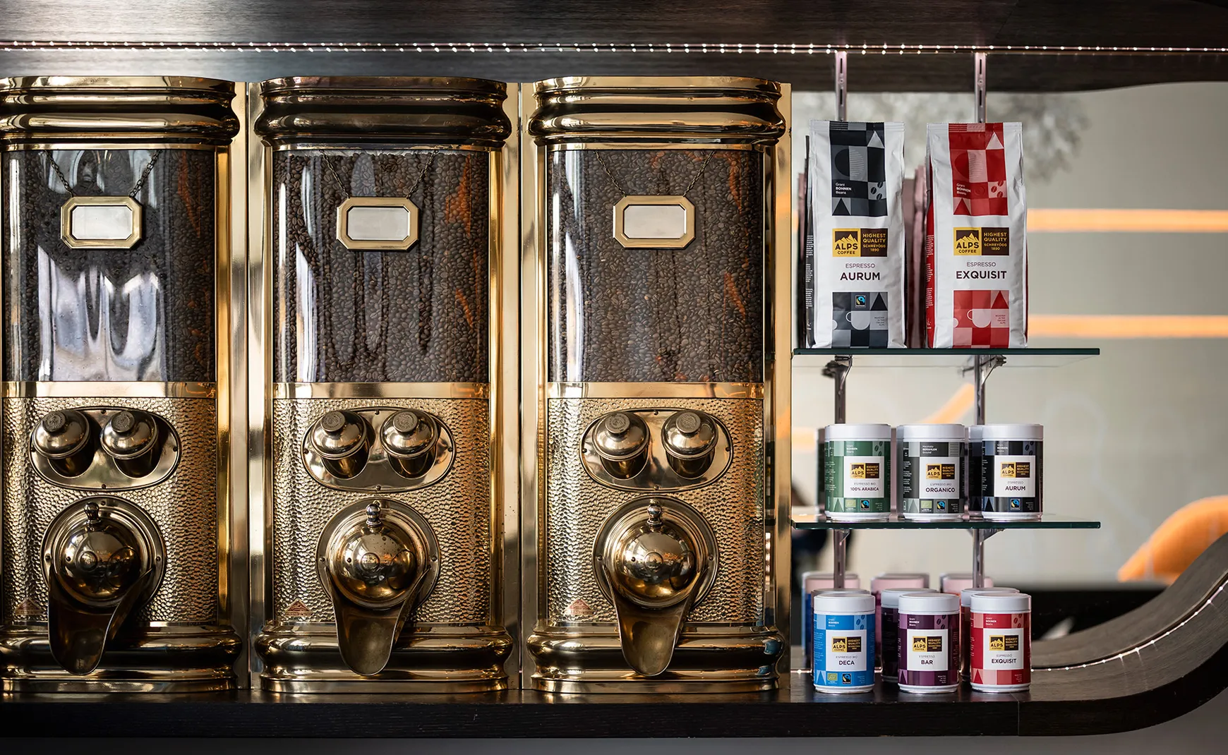Alps Coffee store with three antique brass coffee grinders and product shelf with Aurum and Exquisit packages