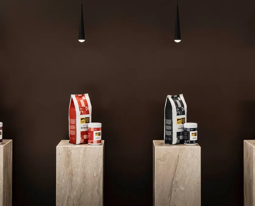 Four Alps Coffee packages Bar, Exquis, Aura and Organic on marble pedestals under pendant lights